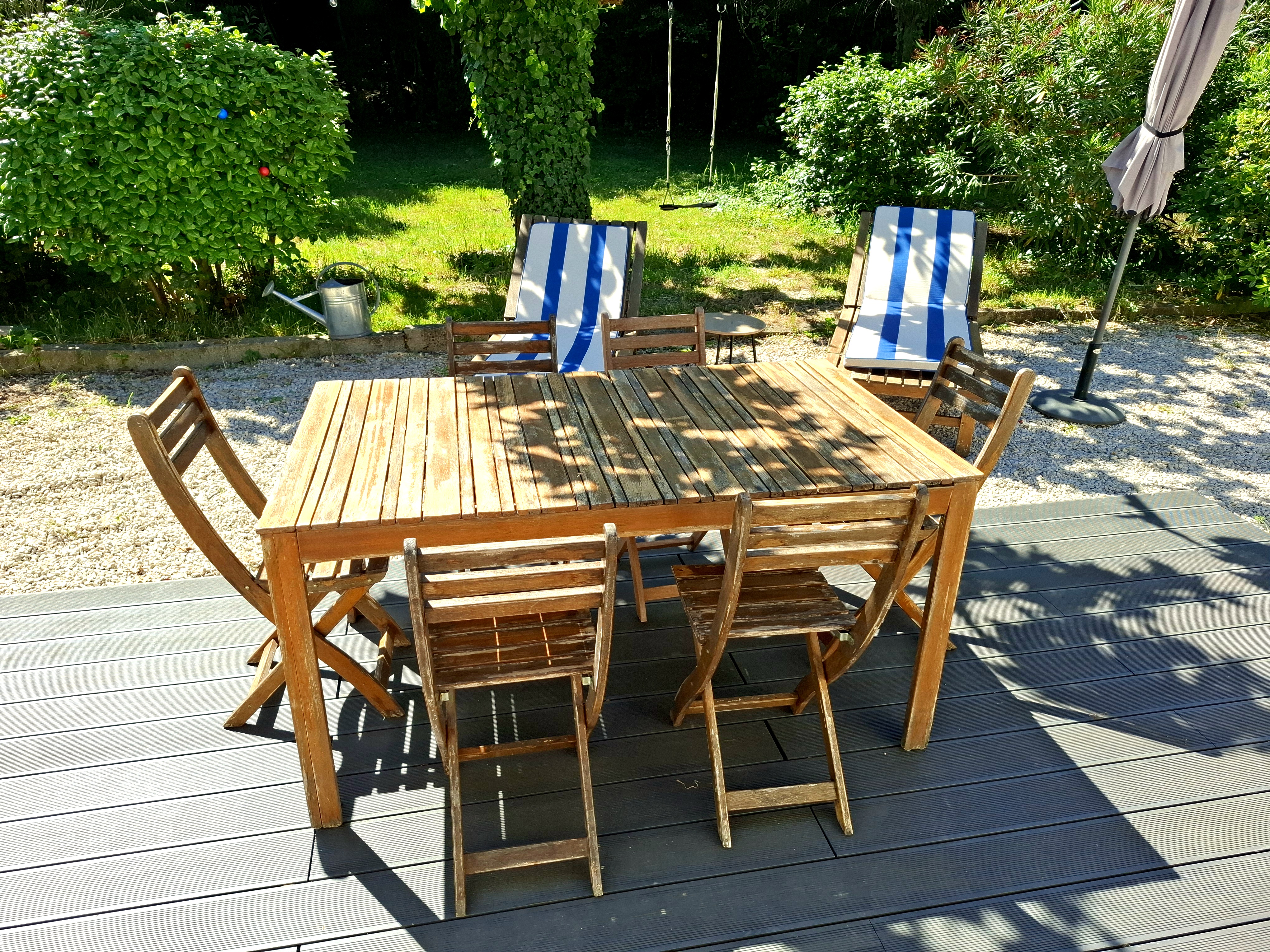 Terrasse ombragée avec table en bois et vue sur le jardin